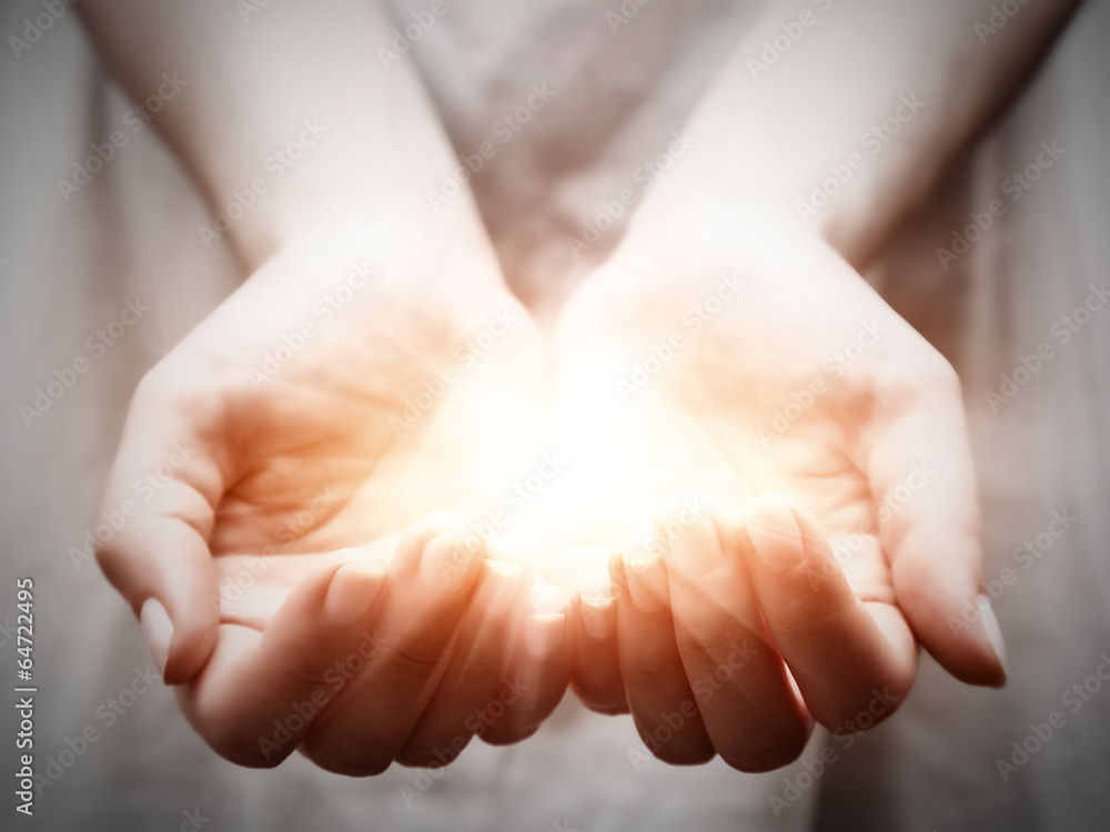 The light in young woman hands. Sharing, giving, protection - obrazy, fototapety, plakaty 