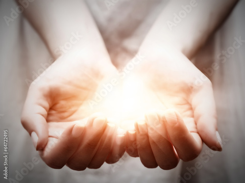 The light in young woman hands. Sharing, giving, protection photo