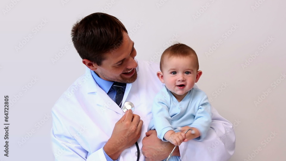 Handsome pediatrician holding baby boy Handsome pediatrician holding baby boy