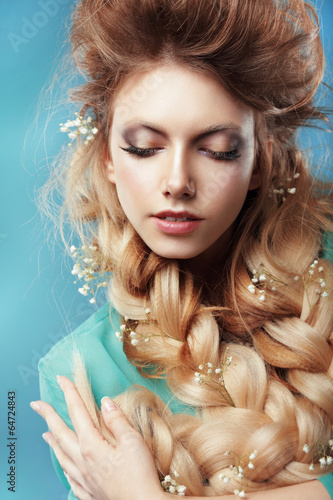 Enjoyment. Woman with Plait and Intertwined Flowers photo