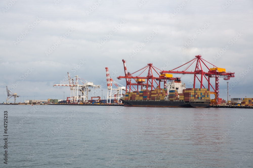 Cargo cranes load ships with containers
