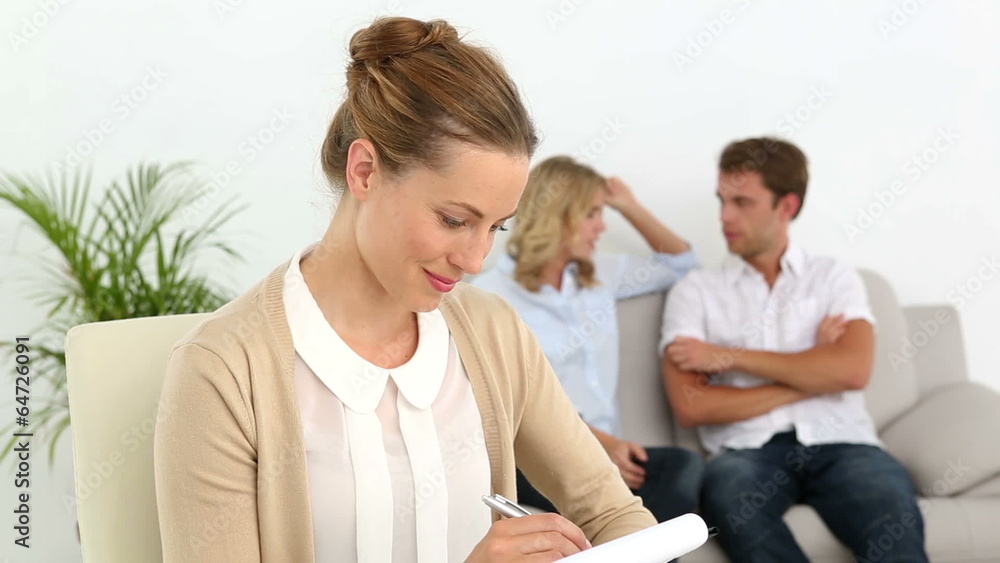 Couple talking on couch behind their therapist Couple talking on couch behind their therapist