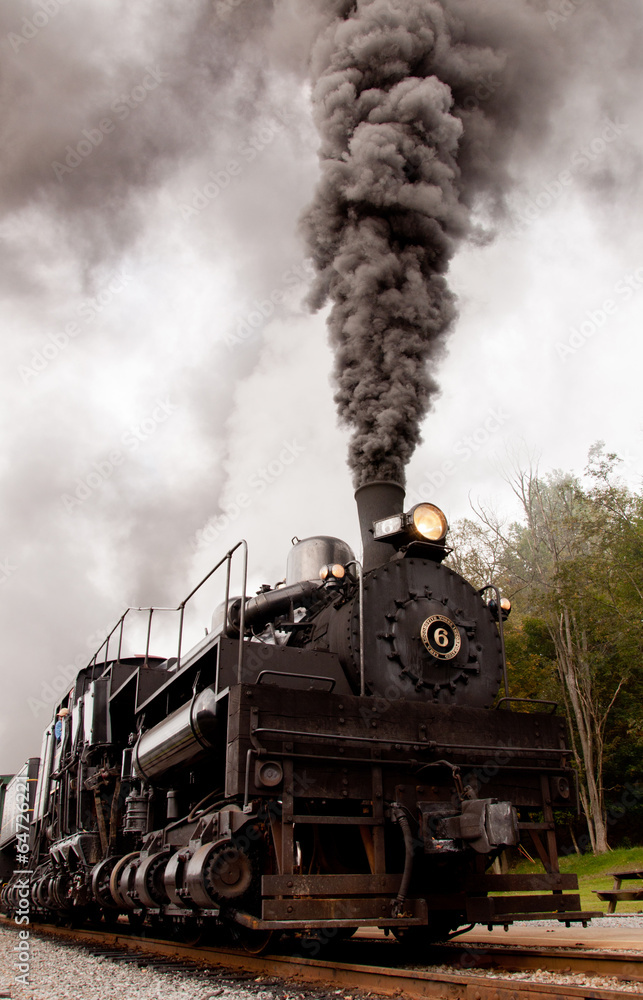 Old steam engine blowing smoke.