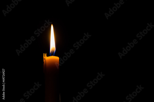 Yellow candle on the dark background