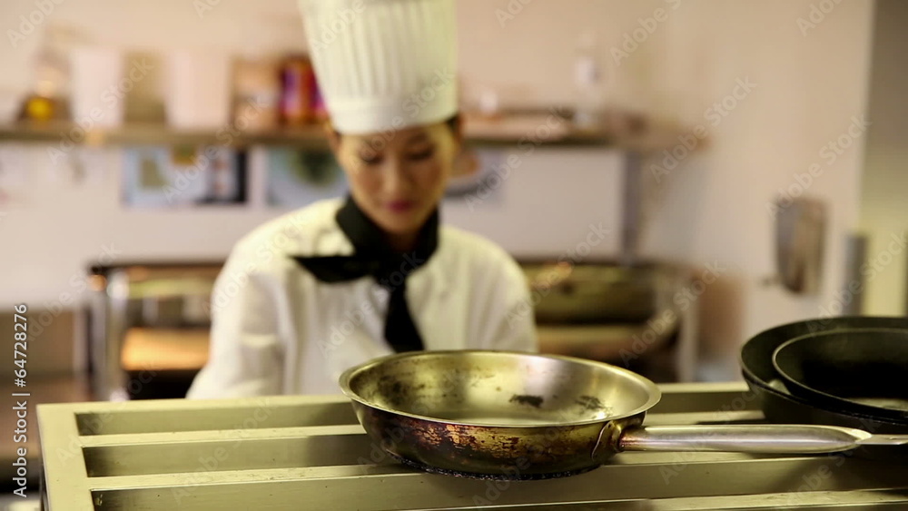 Happy chef taking pots and pans from a shelf