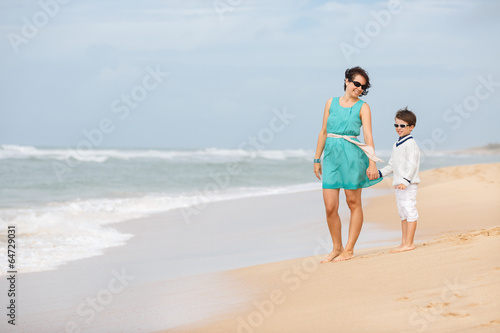 Mother and son walking along a tropical beach