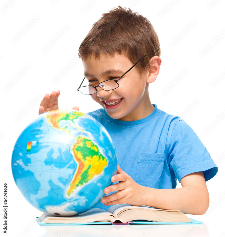 Little boy is examining globe Little boy is examining globe