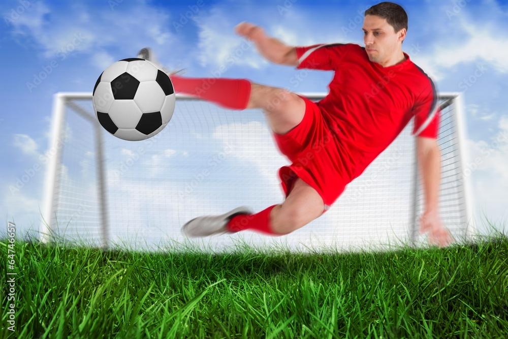 Fit football player jumping and kicking ball Fit football player jumping and kicking ball