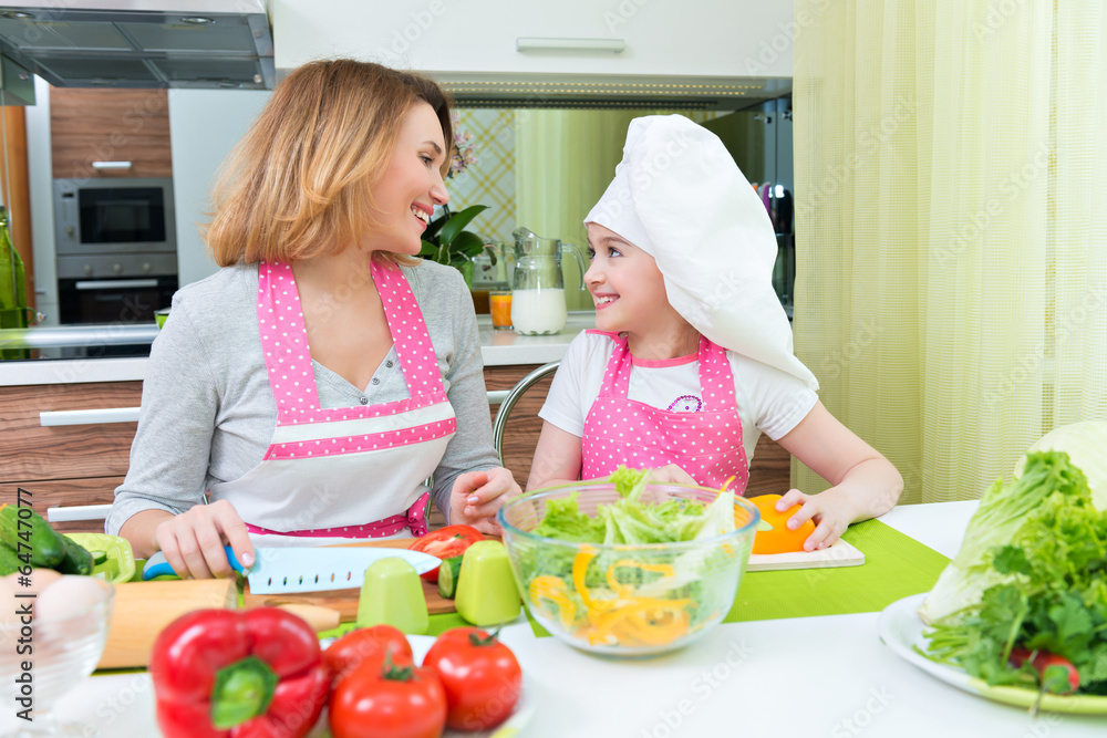 Happy mother and daughter cooking a salad. Happy mother and daughter cooking a salad.