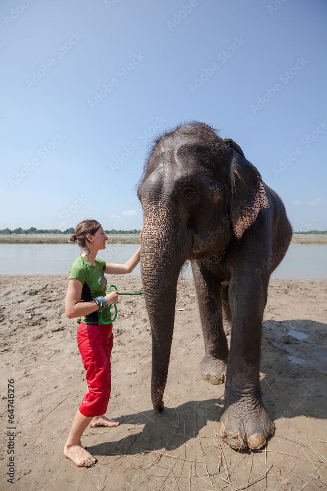 Fototapeta premium Woman plays with elephant in river