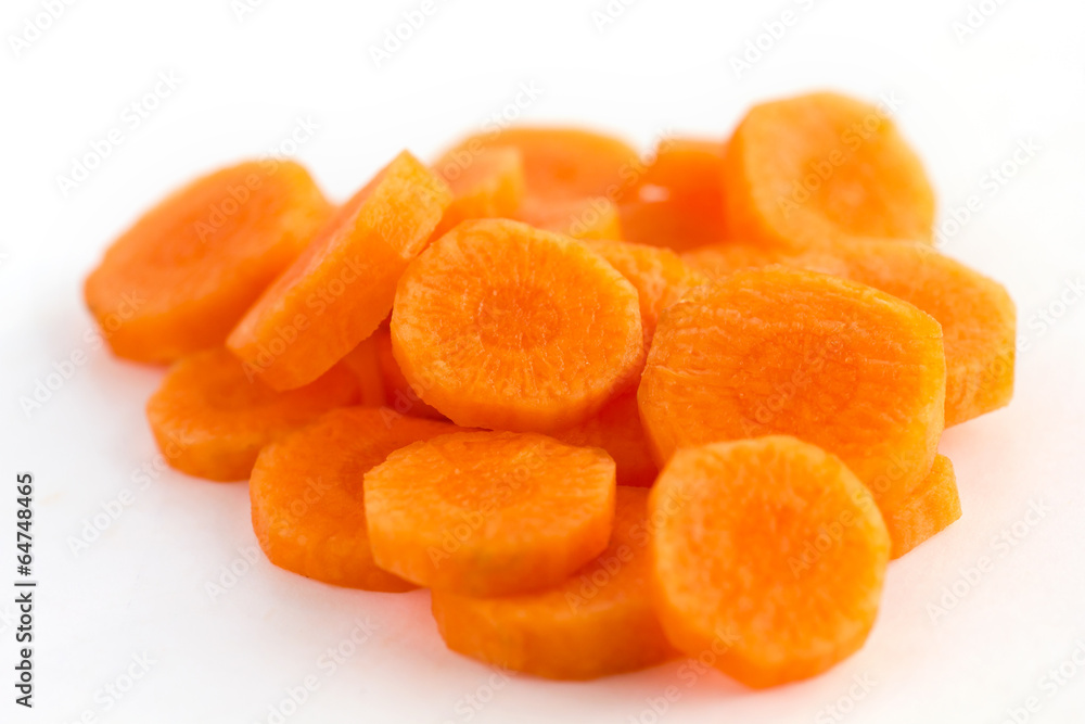 Carrot sliced into circles and arranged on a white surface Carrot sliced into circles and arranged on a white surface