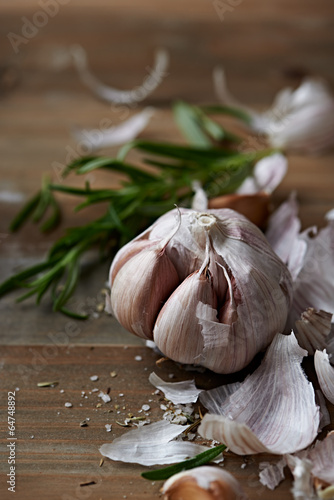 Peeled Garlic Bulb, Rosemary and Salt on a Kitchen Table