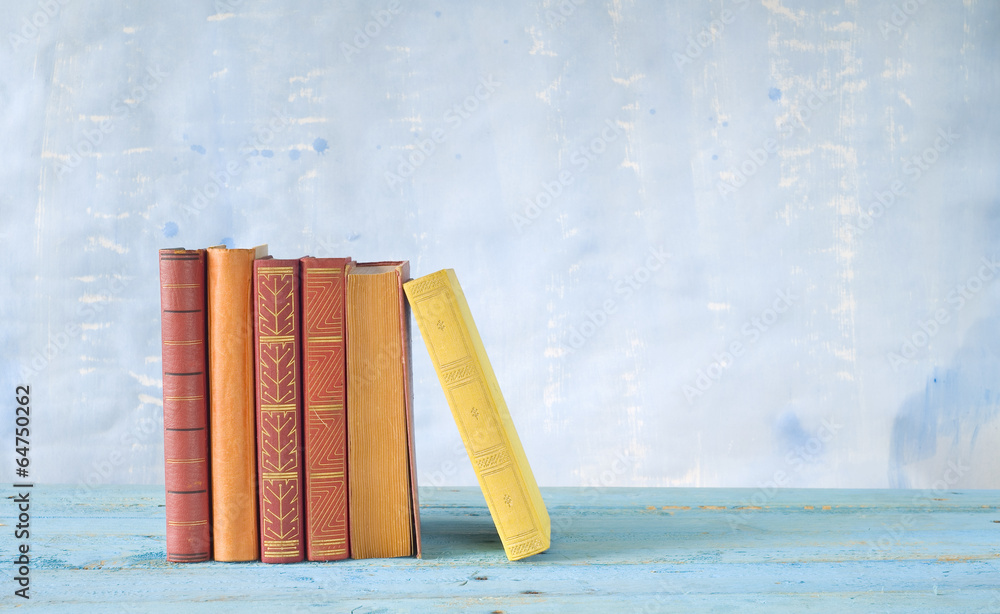 Fototapeta premium row of books, grungy blue background, free copy space