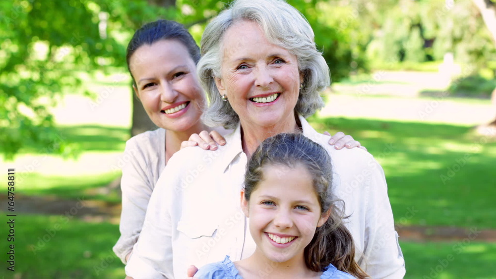 Three generations of women smiling at camera in the park Three generations of women smiling at camera in the park