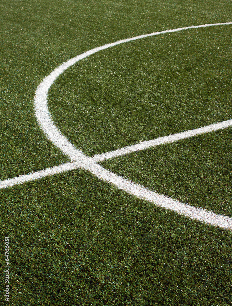 Part of a soccer field with green synthetic grass closeup