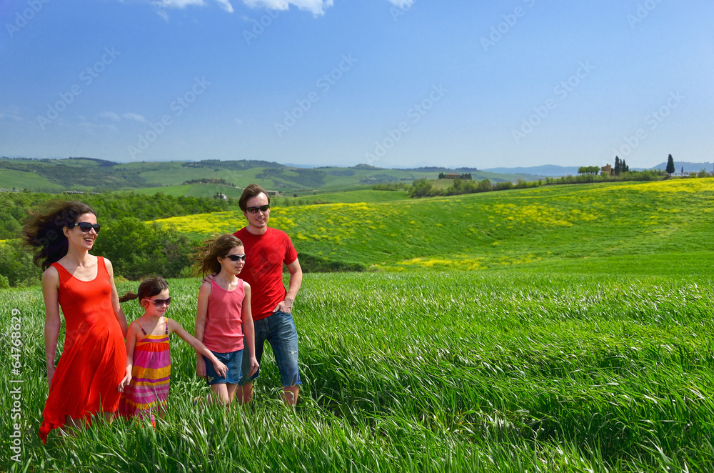 Happy family with children on green field, Tuscany, Italy