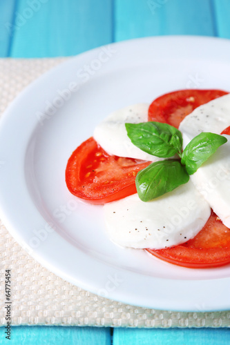 Caprese salad with mozarella cheese, tomatoes and basil