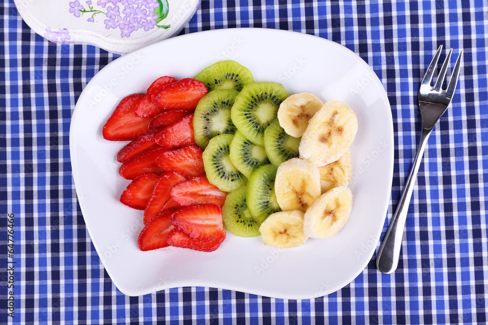 Various sliced fruits on plate on napkin close-up Various sliced fruits on plate on napkin close-up