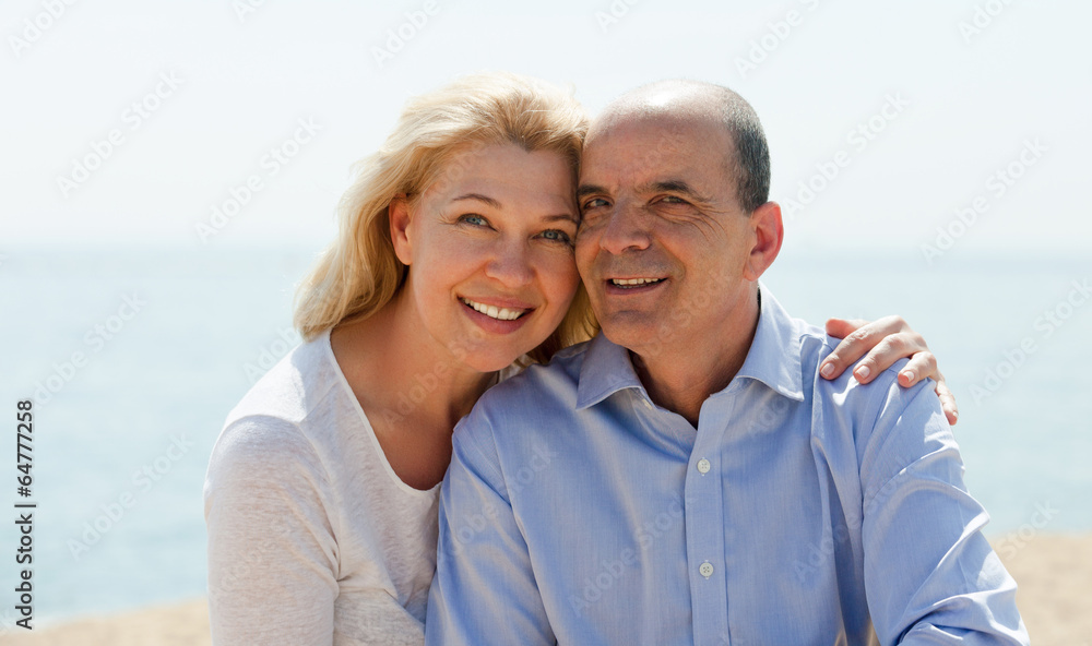 Obraz premium Mature woman and senior at sea beach on vacation smiling