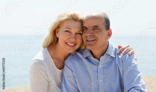 Mature woman and senior at sea beach on vacation smiling