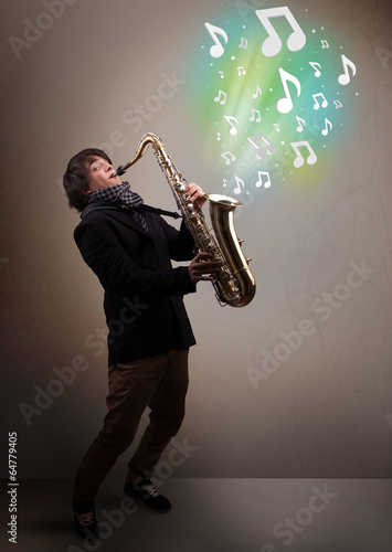 Young musician playing on saxophone while musical notes explodin photo