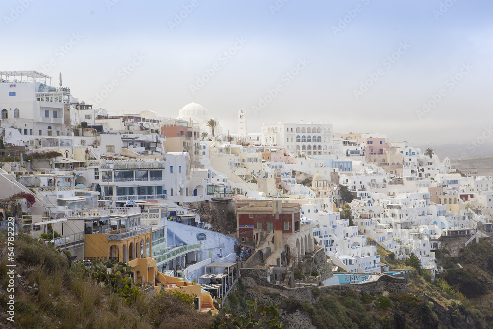 Thira town with white and orange buildings on the rock