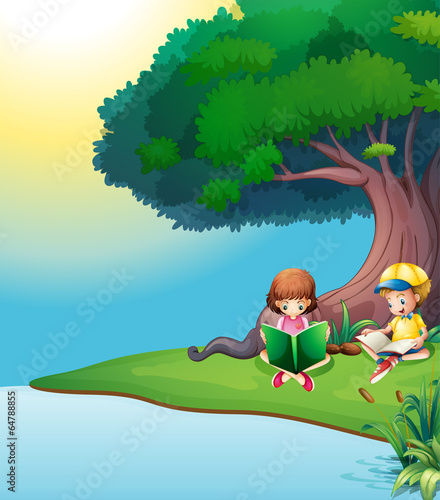 A boy and a girl reading under the tree