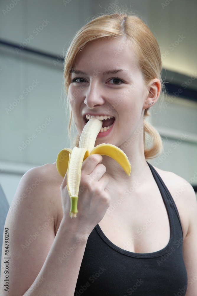 young beautiful woman with a banana in a fitness studio young beautiful woman with a banana in a fitness studio