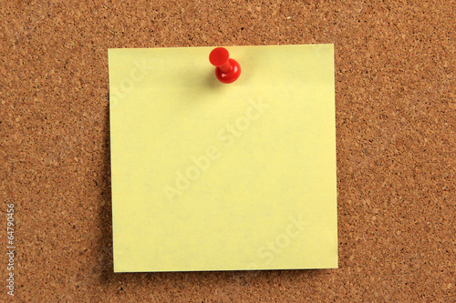 yellow sticky note on a cork board