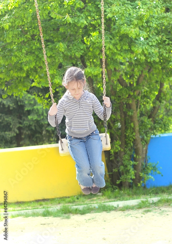 little girl riding on a swing