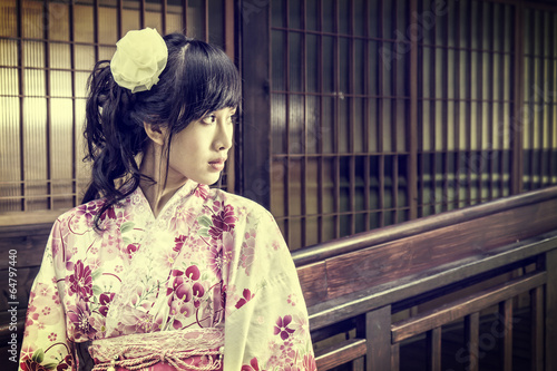 Asian woman wearing a yukata in front of Japanese style windows  © imagesbykenny