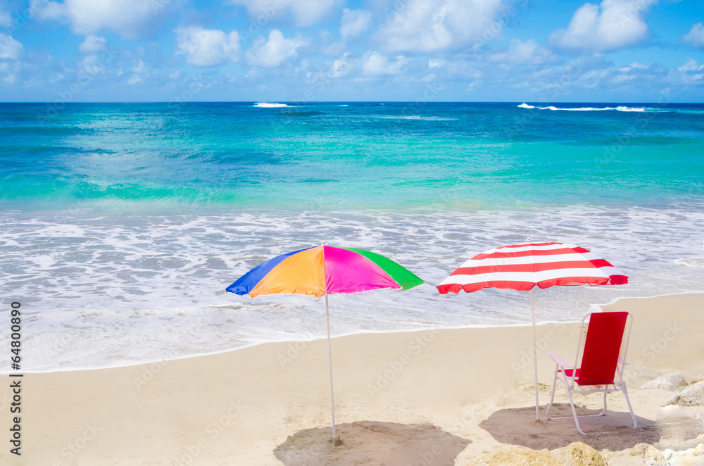 Beach umbrellas and chair by the ocean