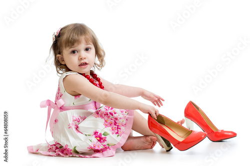 Little girl trying on mummy's shoes photo