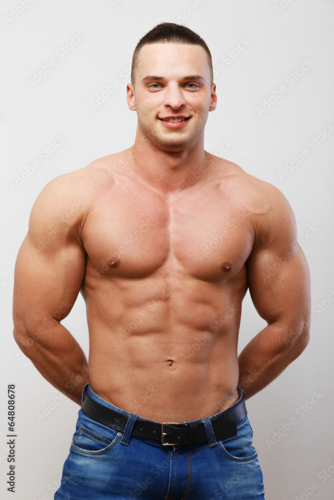 A guy wearing only jeans on a white background