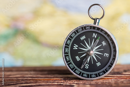 compass on the table against the background of a tourist card