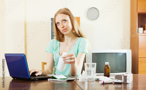 Long-haired wistful woman reading about medications photo