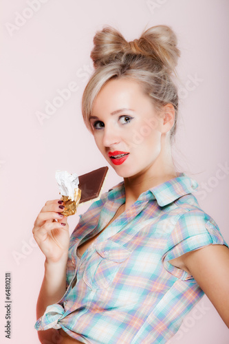 portrait of young woman sexy girl eating chocolate on pink