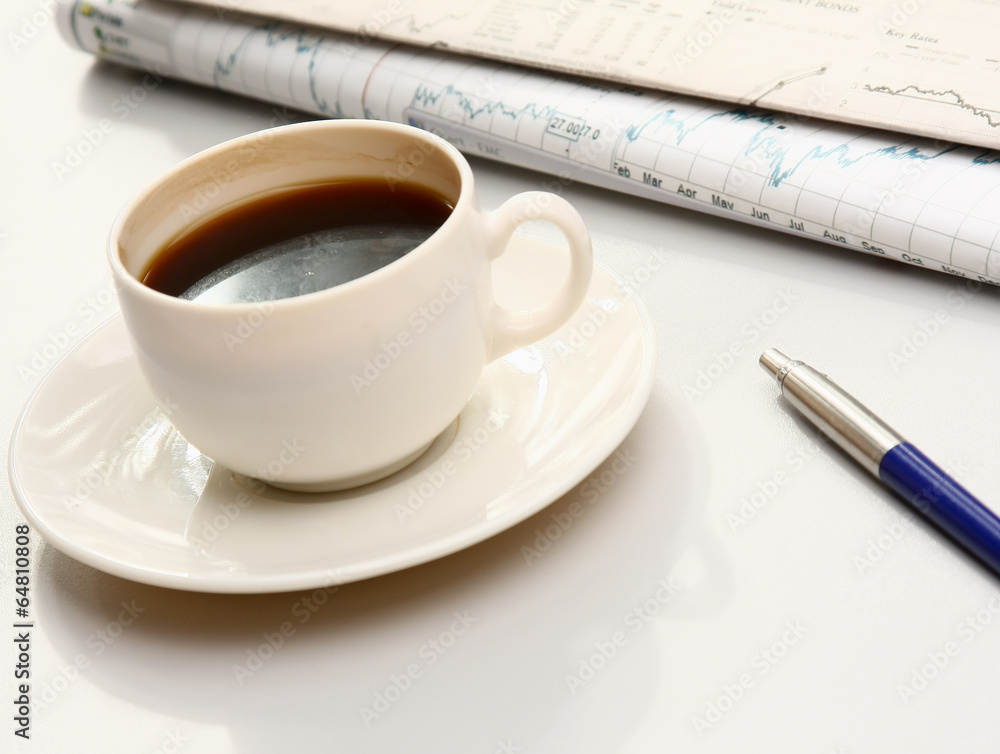 cup of coffee near the laptop and newspapers cup of coffee near the laptop and newspapers