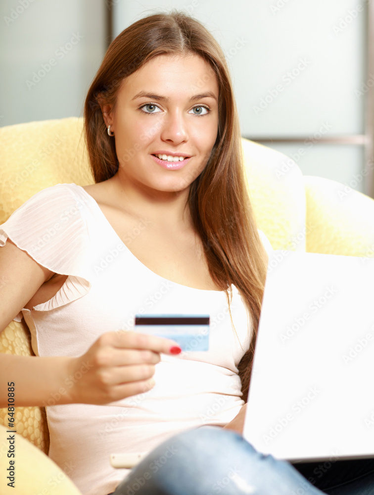 Beautiful happy smiling woman sitting on the sofa with laptop Beautiful happy smiling woman sitting on the sofa with laptop