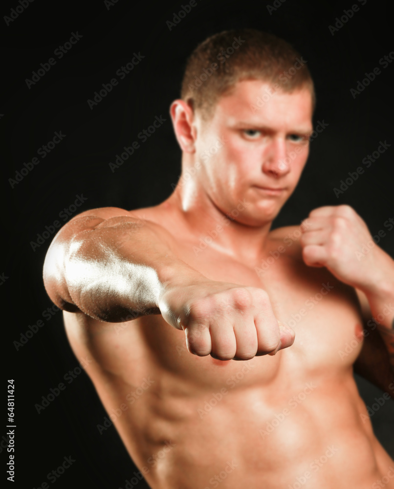 Healthy muscular young man. Isolated on black background
