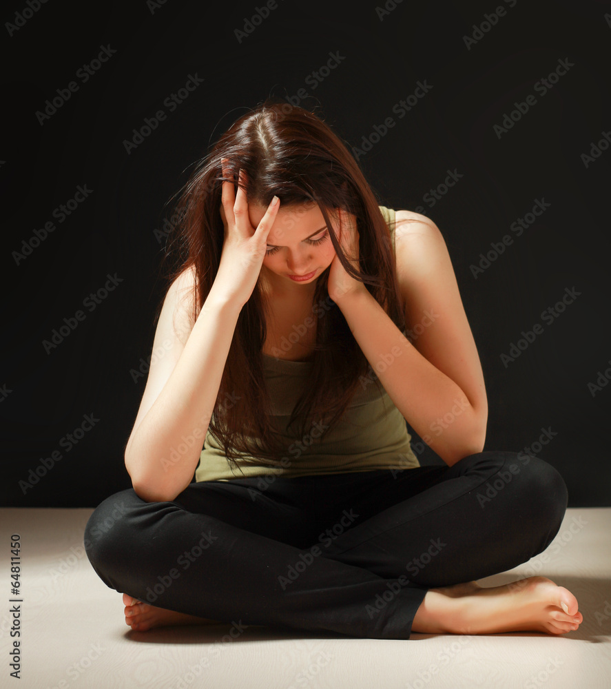 Depressed woman sitting on floor with eyes closed Depressed woman sitting on floor with eyes closed