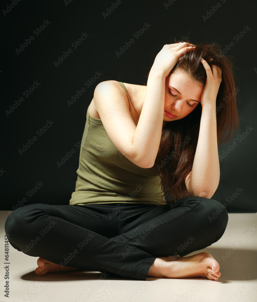 Depressed woman sitting on floor with eyes closed Depressed woman sitting on floor with eyes closed