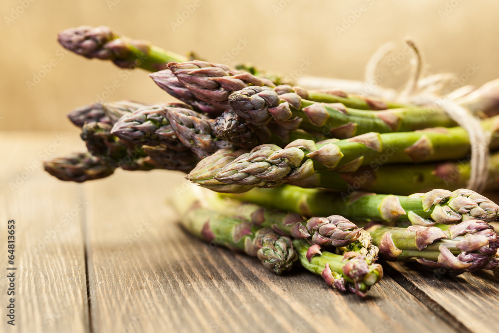 Bunch of young asparagus on wooden table Bunch of young asparagus on wooden table