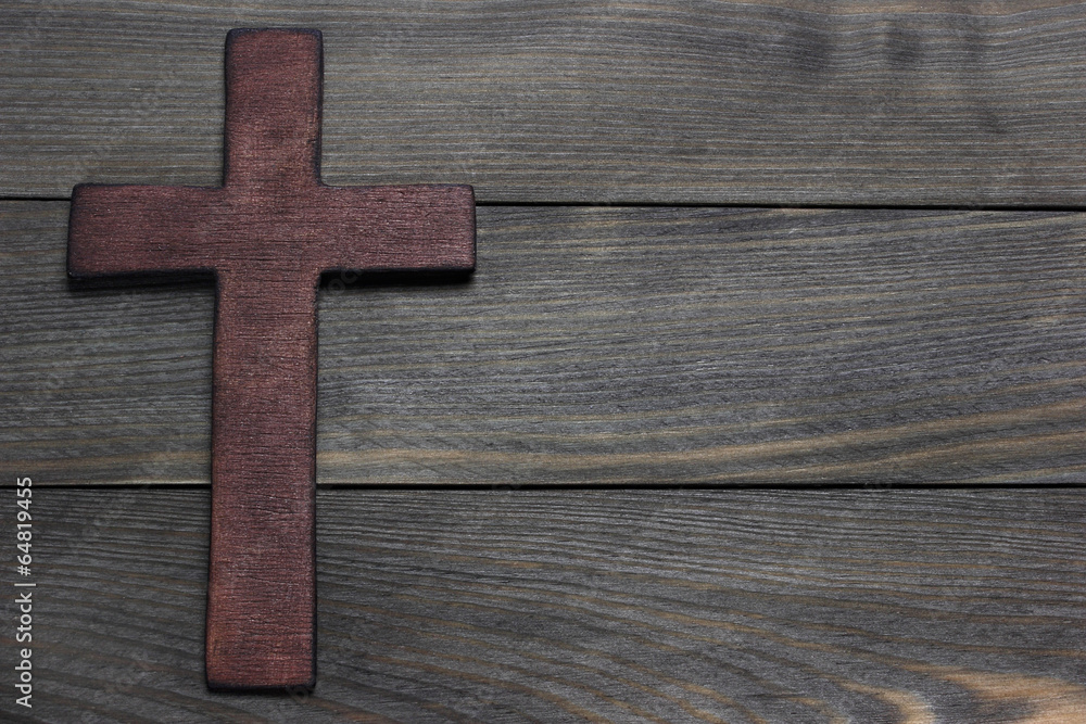 Wooden cross on wooden background