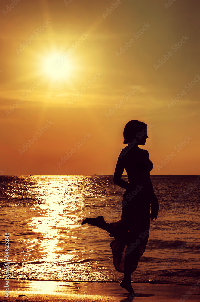 silhouette of a girl against the sunset sea