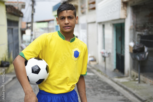 Young Brazilian Football Player Holding Soccer Ball on Street © lazyllama