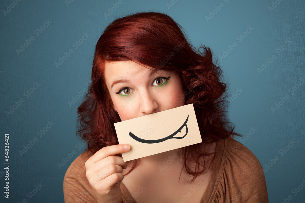 Pretty young girl holding white card with smile drawing Pretty young girl holding white card with smile drawing