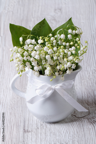 Fototapeta Naklejka Na Ścianę i Meble -  Beautiful bouquet of lilies of the valley in a white jug