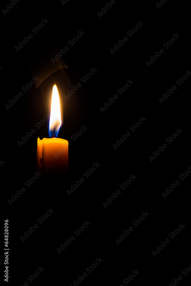 Yellow candle on the dark background Yellow candle on the dark background