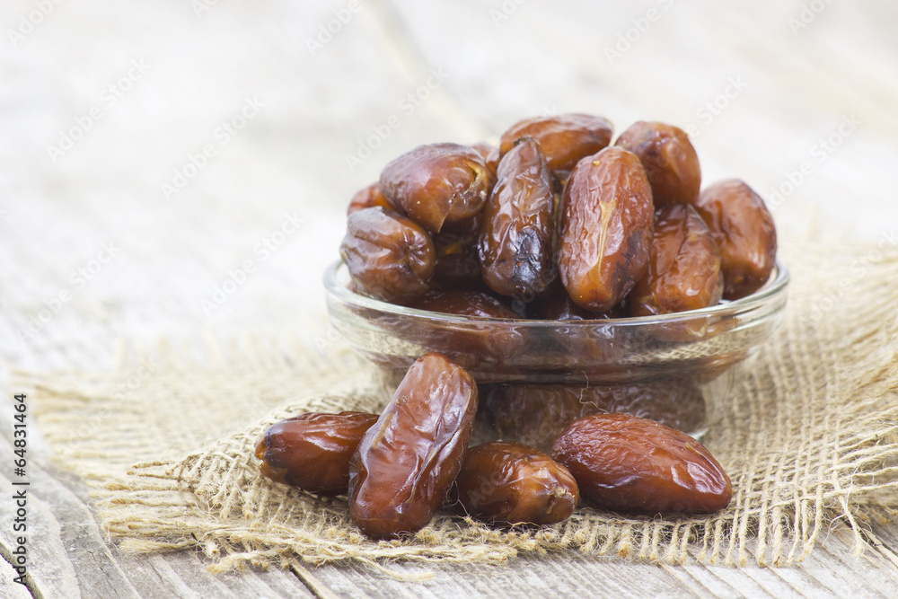 dried dates in a bowl on wooden background dried dates in a bowl on wooden background